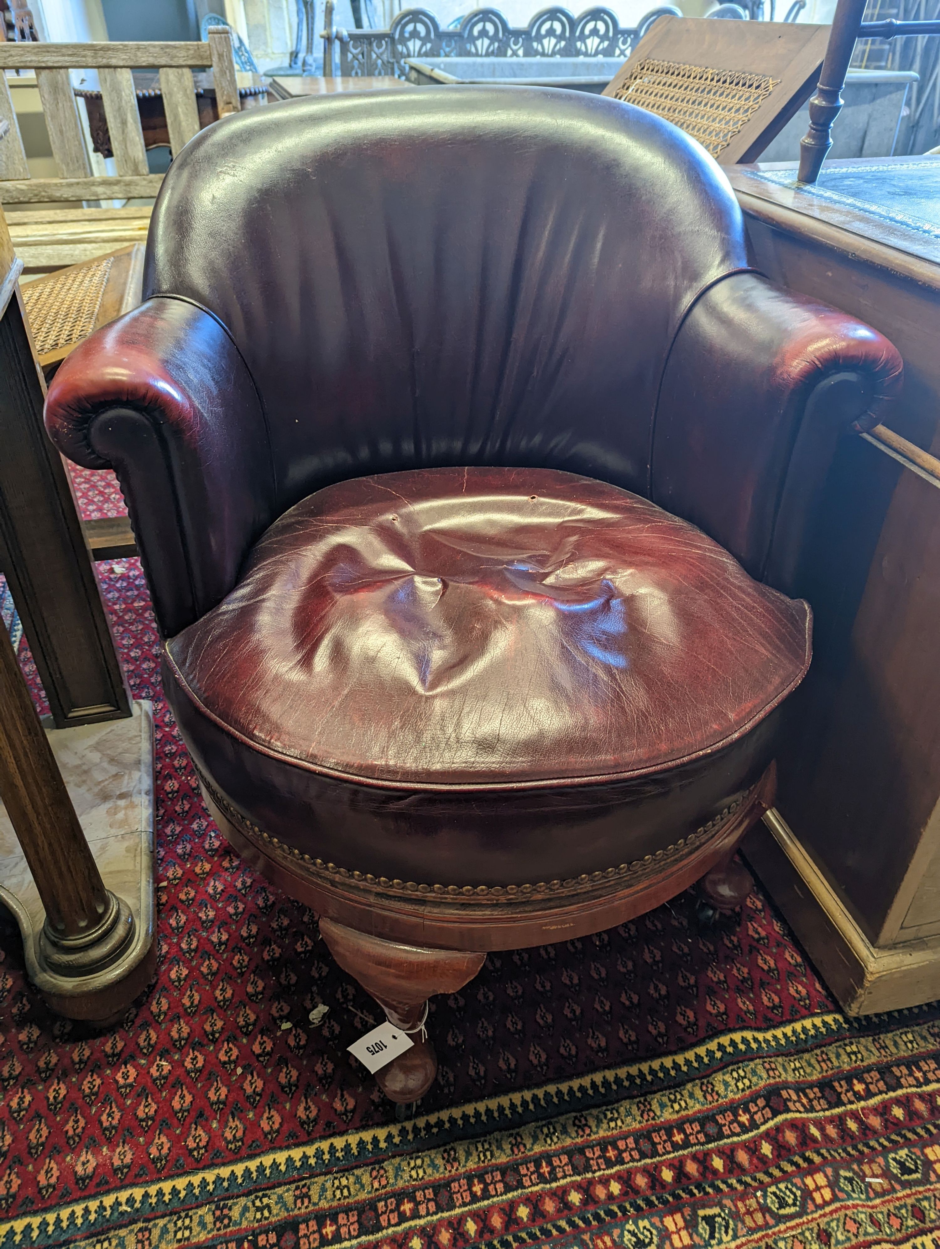 An early 20th century oak and burgundy leather tub framed swivel desk chair, width 70cm, depth 60cm, height 82cm